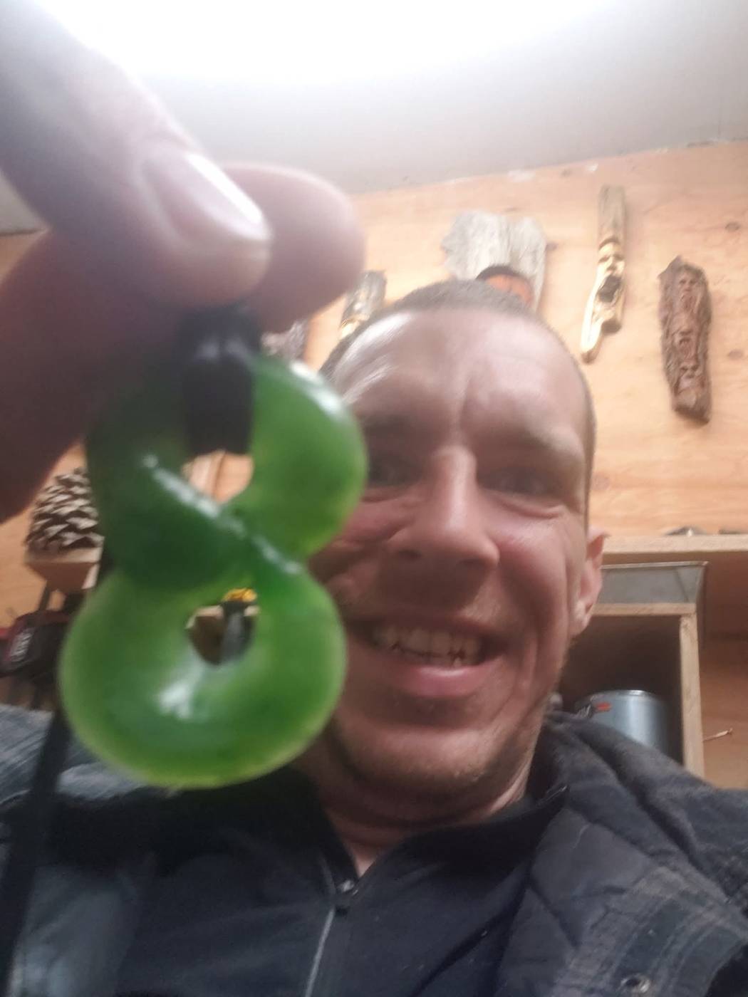 Holding a polished green jade figure-eight pendant